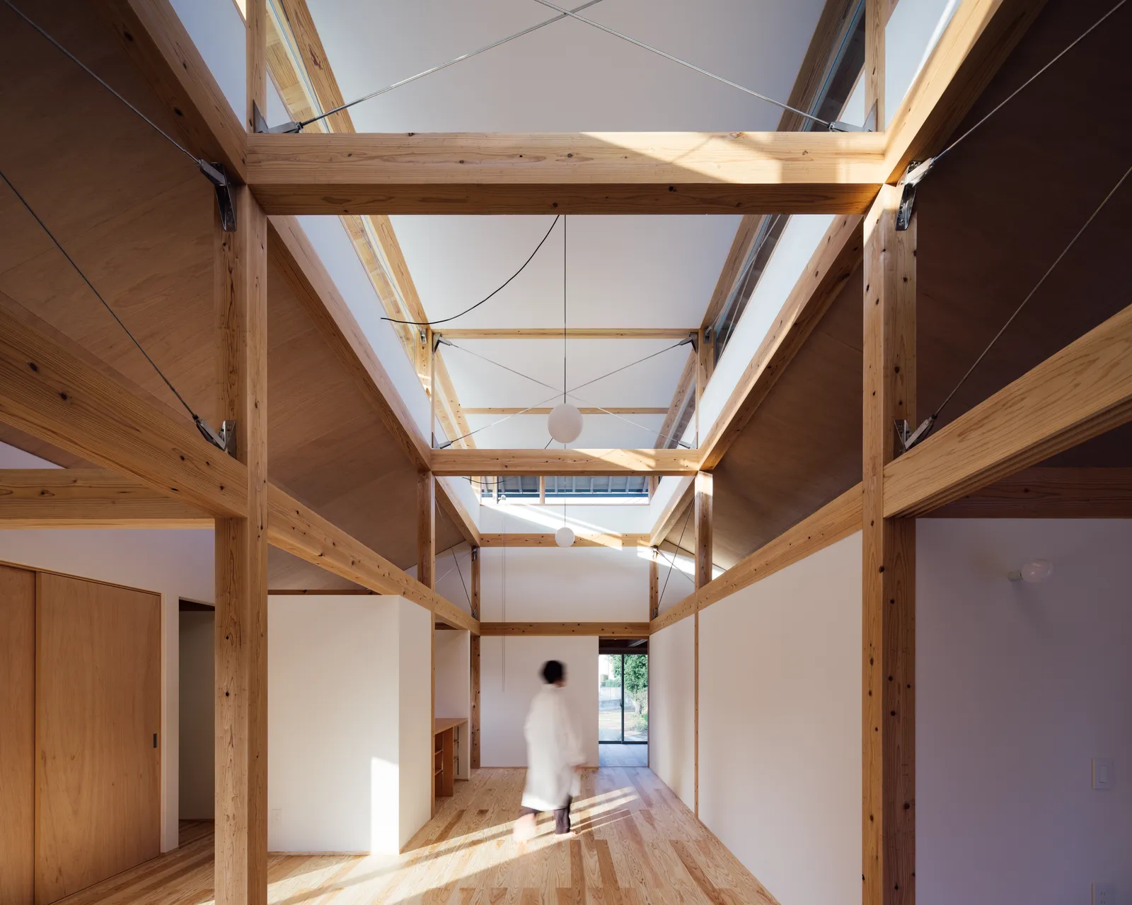 持ち上げた屋根の間から光を取り込み、住宅街の中でも安定した採光を実現している。