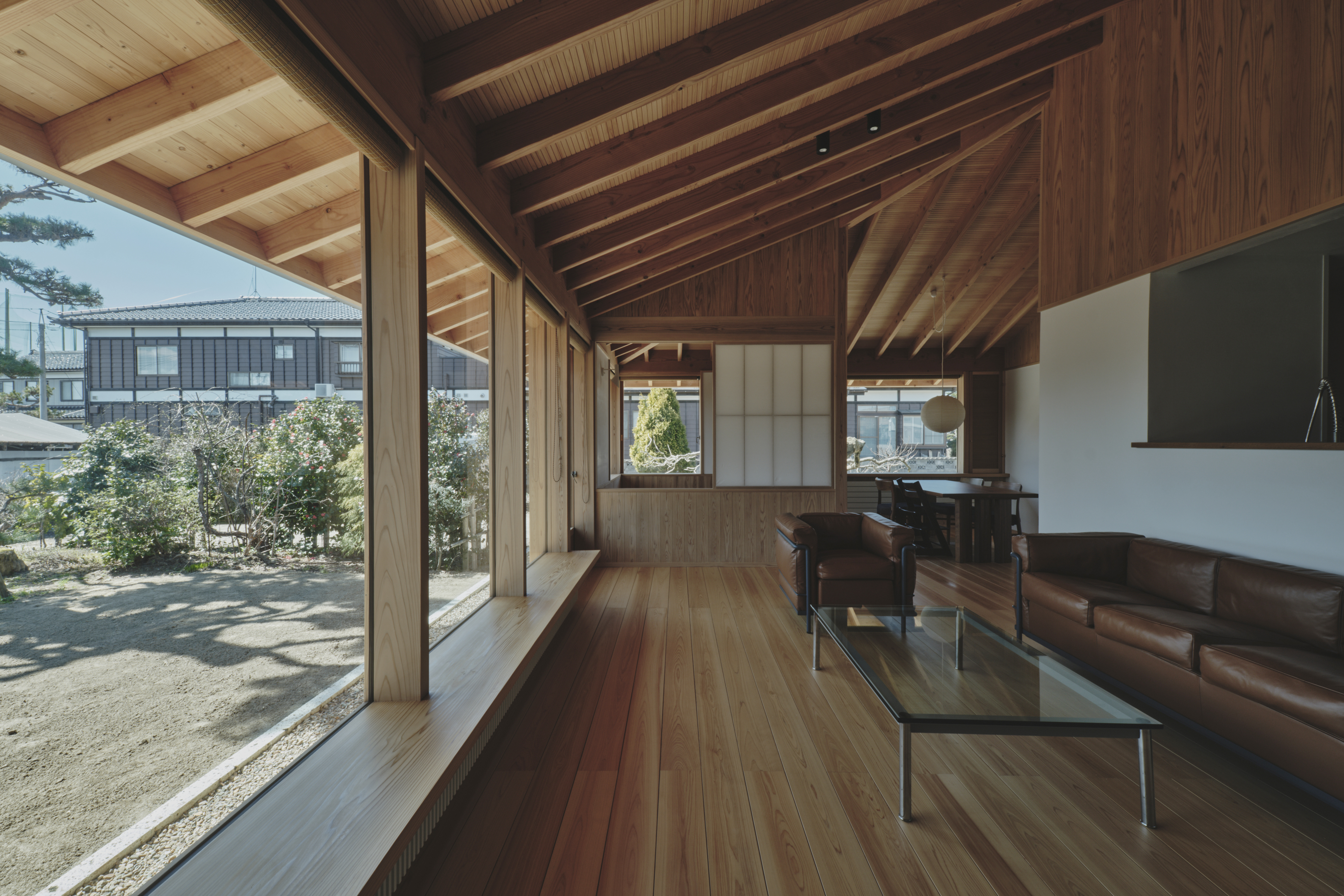 低く抑えた軒先と木の天井が、外部とのつながりを感じさせながら、守られているような安心感をもたらす。