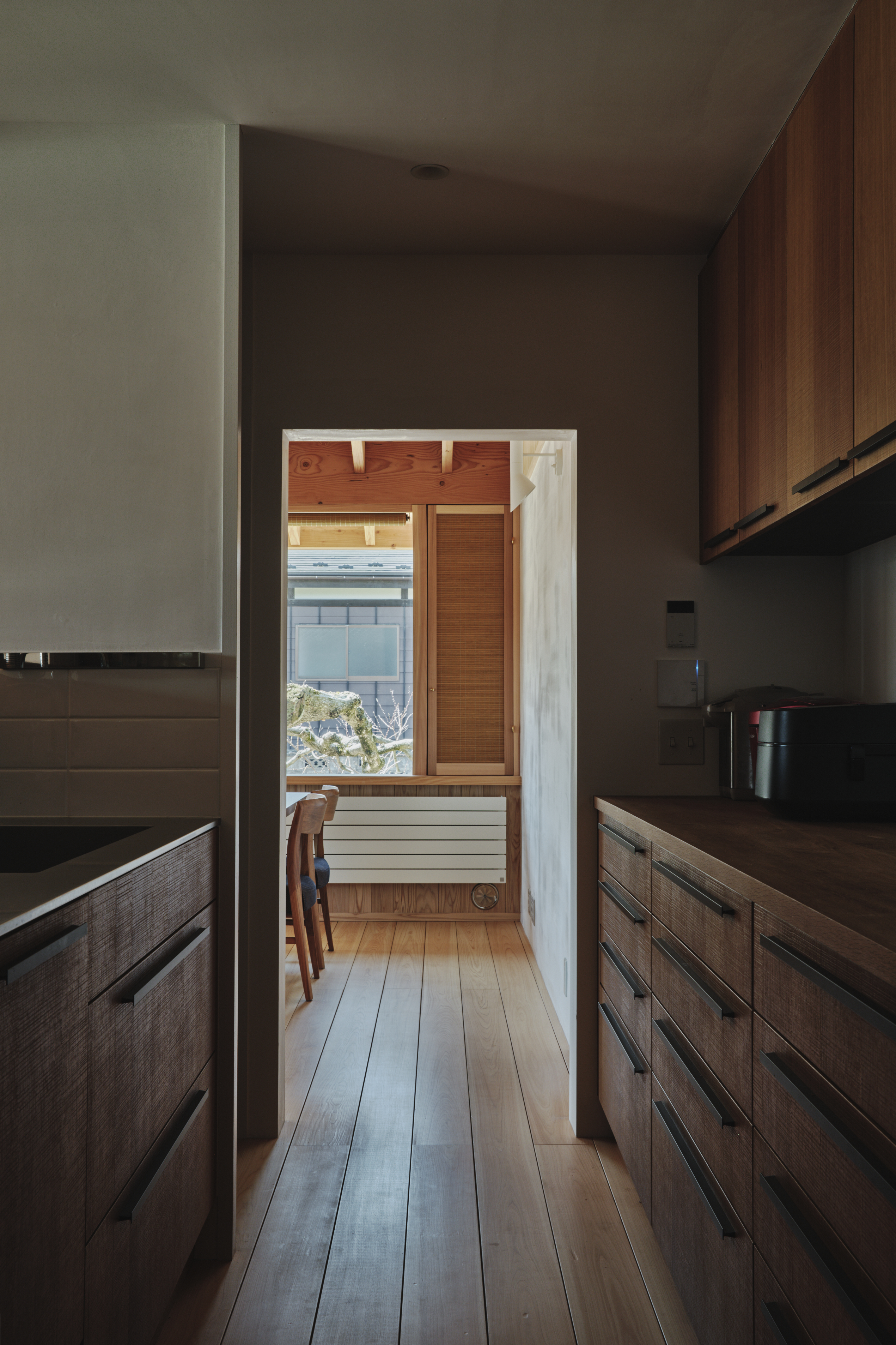 台所を中心に各室がゆるやかにつながる内観。回遊性のある動線が、日々の家事と暮らしを支えている。