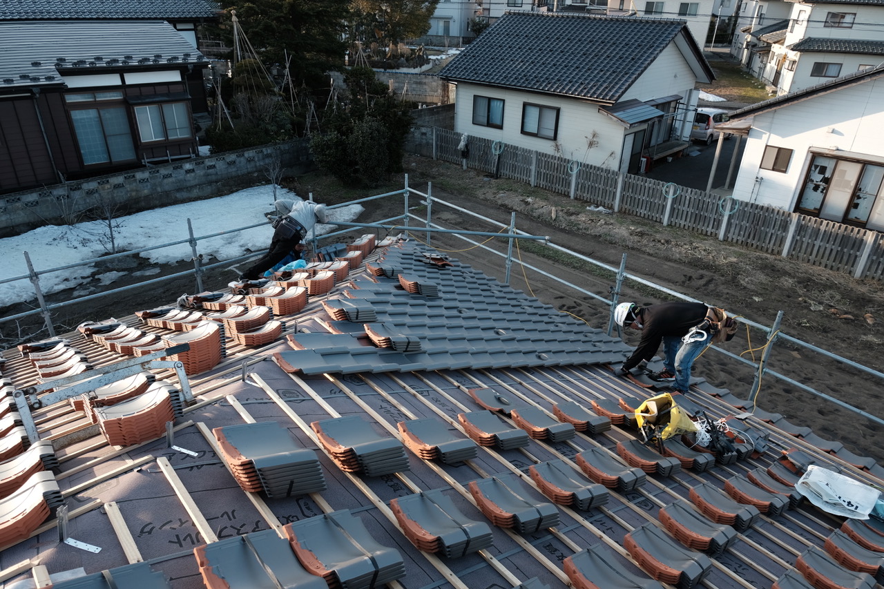 地域の気候や施工者の知見を踏まえながら、瓦屋根を丁寧に納めていく『鶴岡の家』の施工風景。